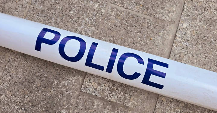 File image: White police tape with blue lettering on concrete ground