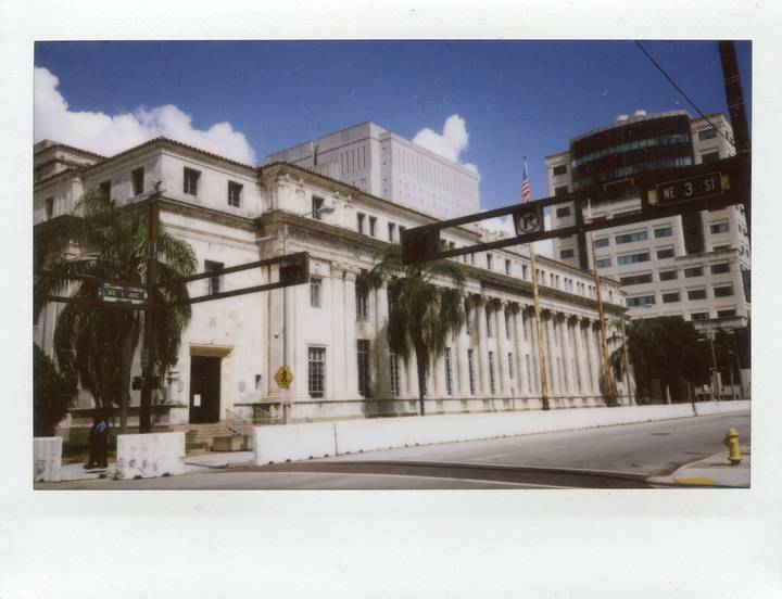 File image: White classical courthouse with columns, palm trees, and American flag. Exterior view.