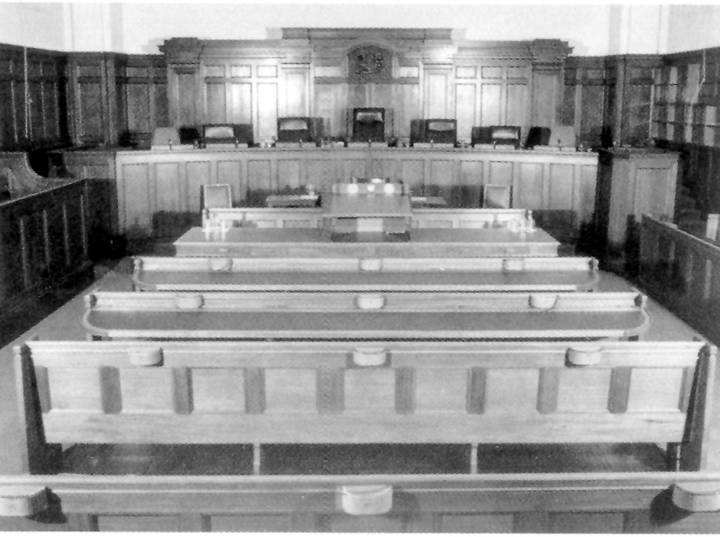 File image: Black and white interior view of tiered courthouse seating and judge's bench area