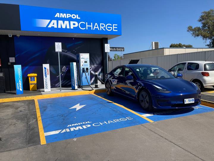 Blue Tesla Model 3 plugged into AMPOL AMPCHARGE public charging station in Australia.