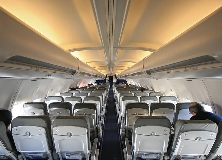 File image: Airplane cabin interior with passenger seating rows and overhead compartments
