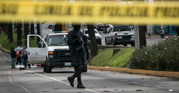 File image: Armed tactical police and officers behind yellow police tape at scene with patrol vehicles.