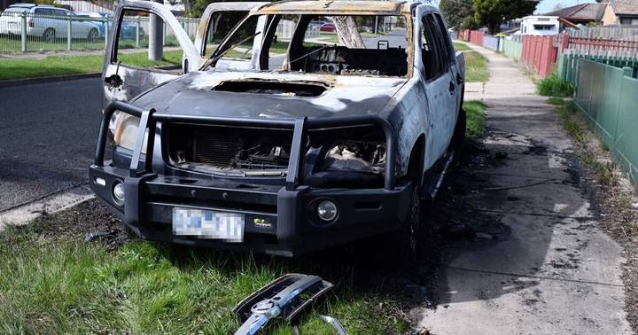 Charred Holden ute with blown-out windows and fire-damaged bodywork on street