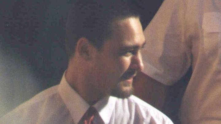 James Vlassakis. Man in shirt and tie photographed indoors in warm lighting