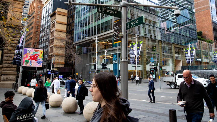 Busy Sydney street intersection at Martin Place and Pitt Street with pedestrians, shopfronts, and commercial buildings