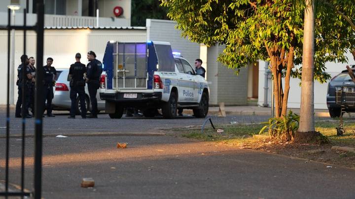 Police van and uniformed officers at street scene with buildings, appropriate for sensitive story policy