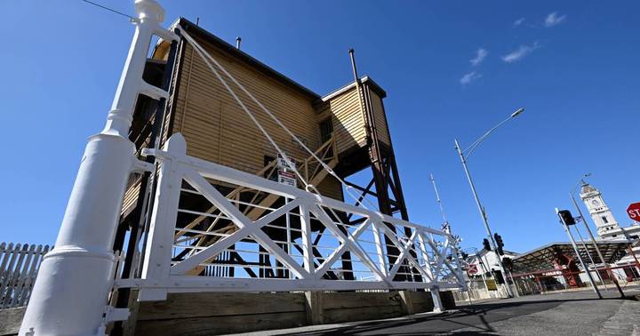 Wooden level crossing gates with white X-bracing displayed as heritage monument at Ballarat station