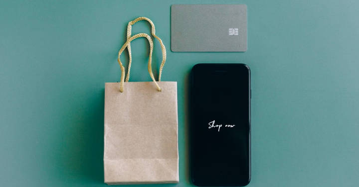 File image: Styled shopping scene: bag, card, and smartphone on teal