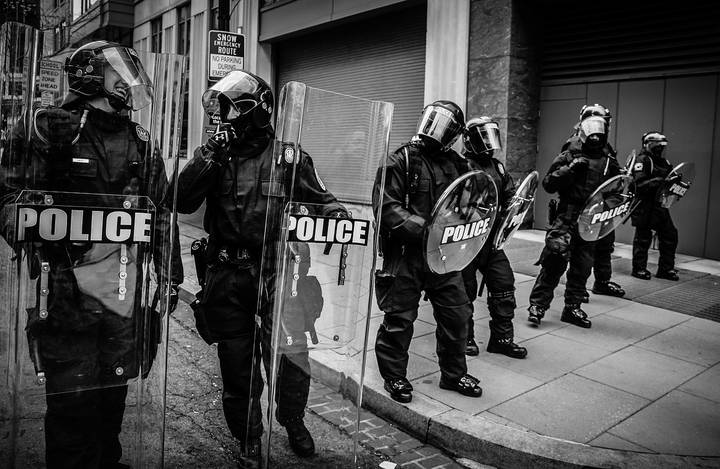 Riot police in full tactical gear lined up during protest confrontation