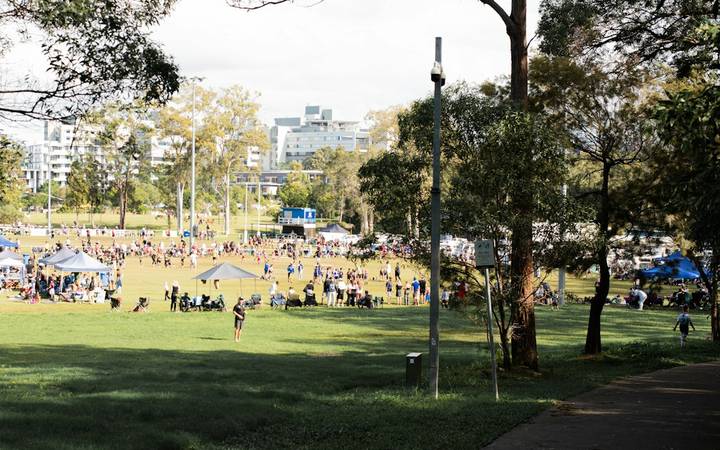 File image: Crowd gathered on grassy oval with tents and eucalyptus trees