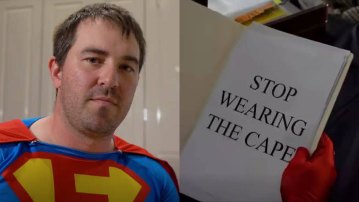 Matthew McKay. Man in Superman costume examines sign reading Stop Wearing the Cape