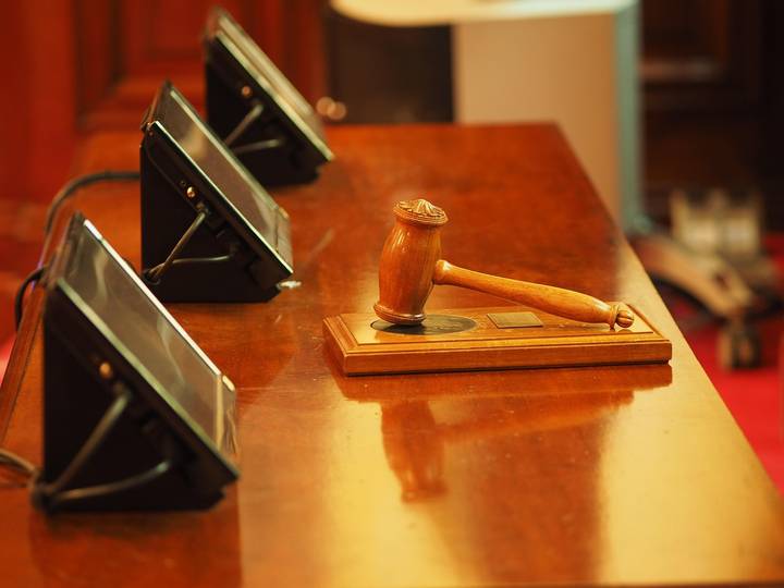 File image: Wooden gavel on podium with microphones, courtroom setting