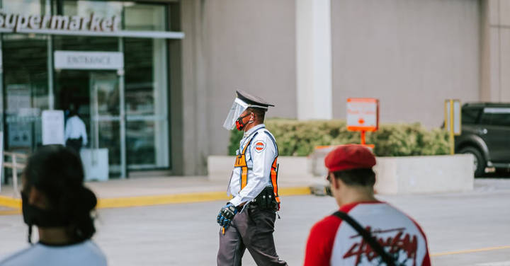 Security officer in light blue uniform standing in parking area