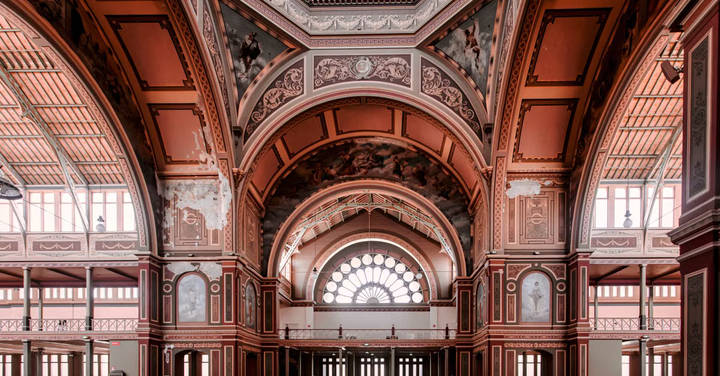 Ornate red arches and decorative architecture of a historic building interior