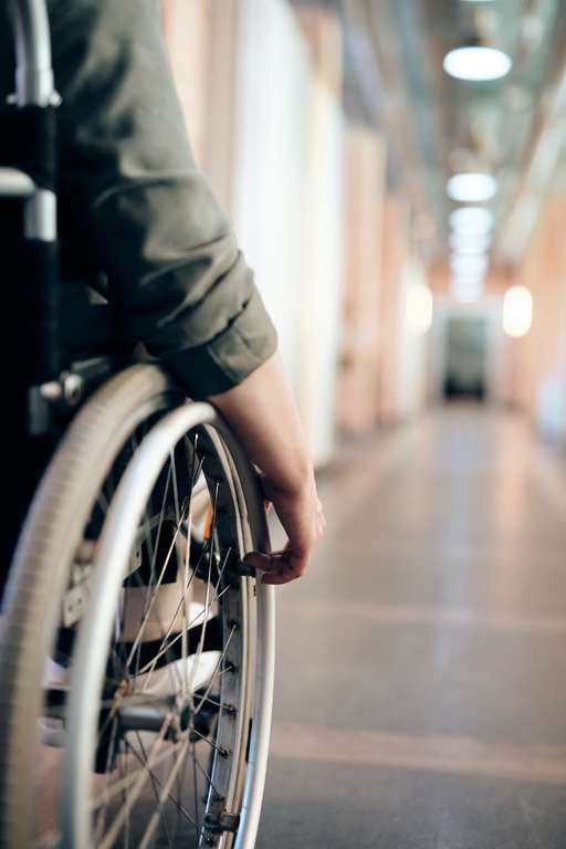 A person in a wheelchair is effortlessly maneuvering down a hallway.