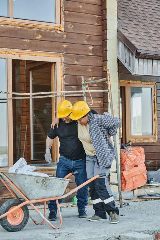 A construction worker helps his colleague who was injured during his work