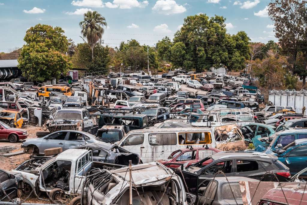 A lot of cars are parked in a salvage yard.