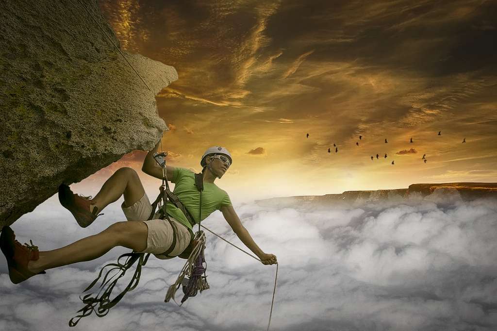 A rock climbing instructor, fearlessly tackles the challenge of scaling a cliff that seems to be floating in the clouds.