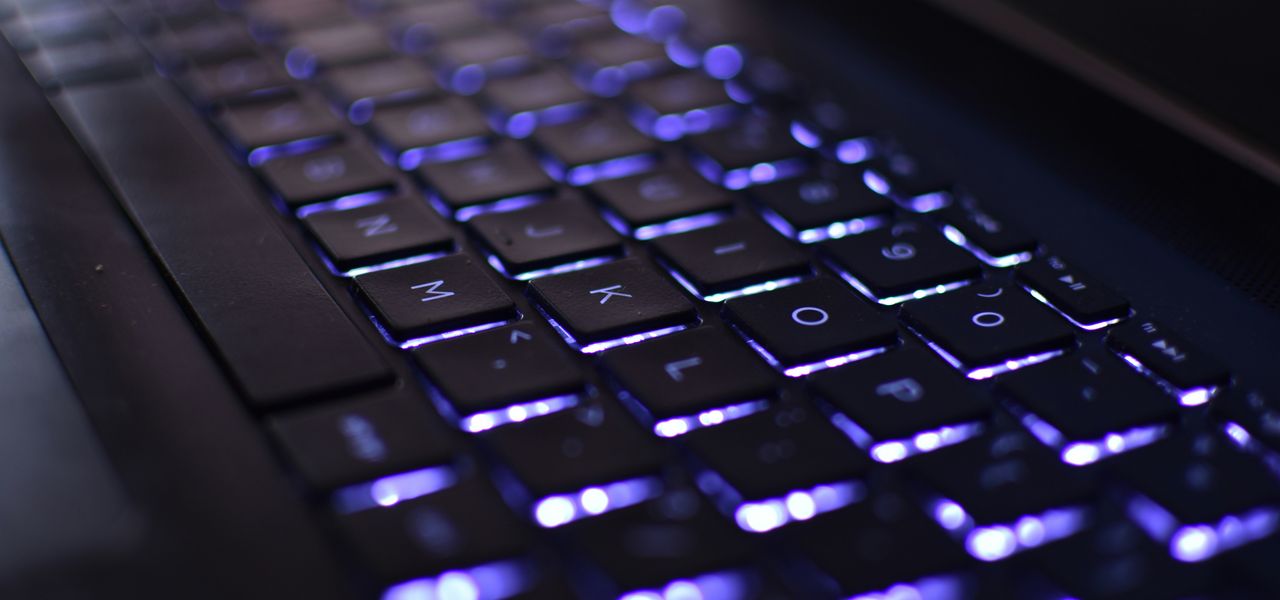 a close up of a computer keyboard with blue lights
