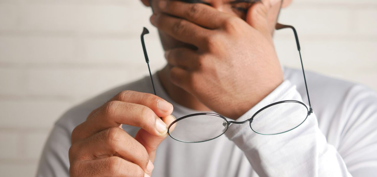 a man holding a pair of glasses up to his face