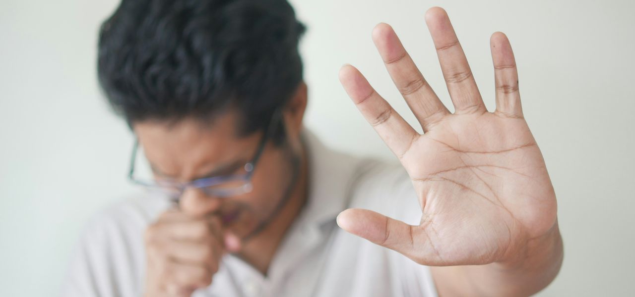 a man holding his hand up in front of his face