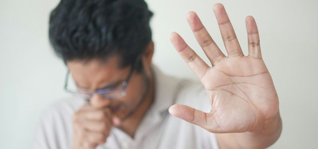 a man holding his hand up in front of his face