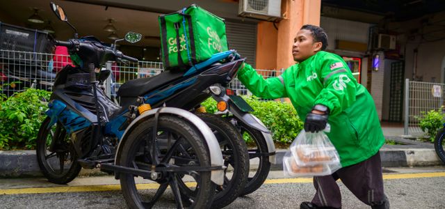 a man in a green jacket is next to a motorcycle