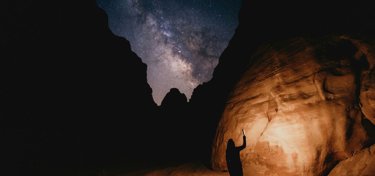 a man standing in the middle of a desert at night