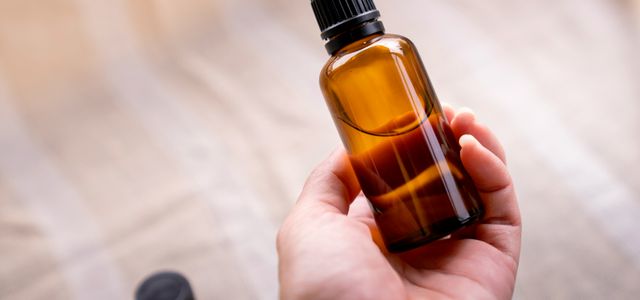 a person holding a bottle of essential oils