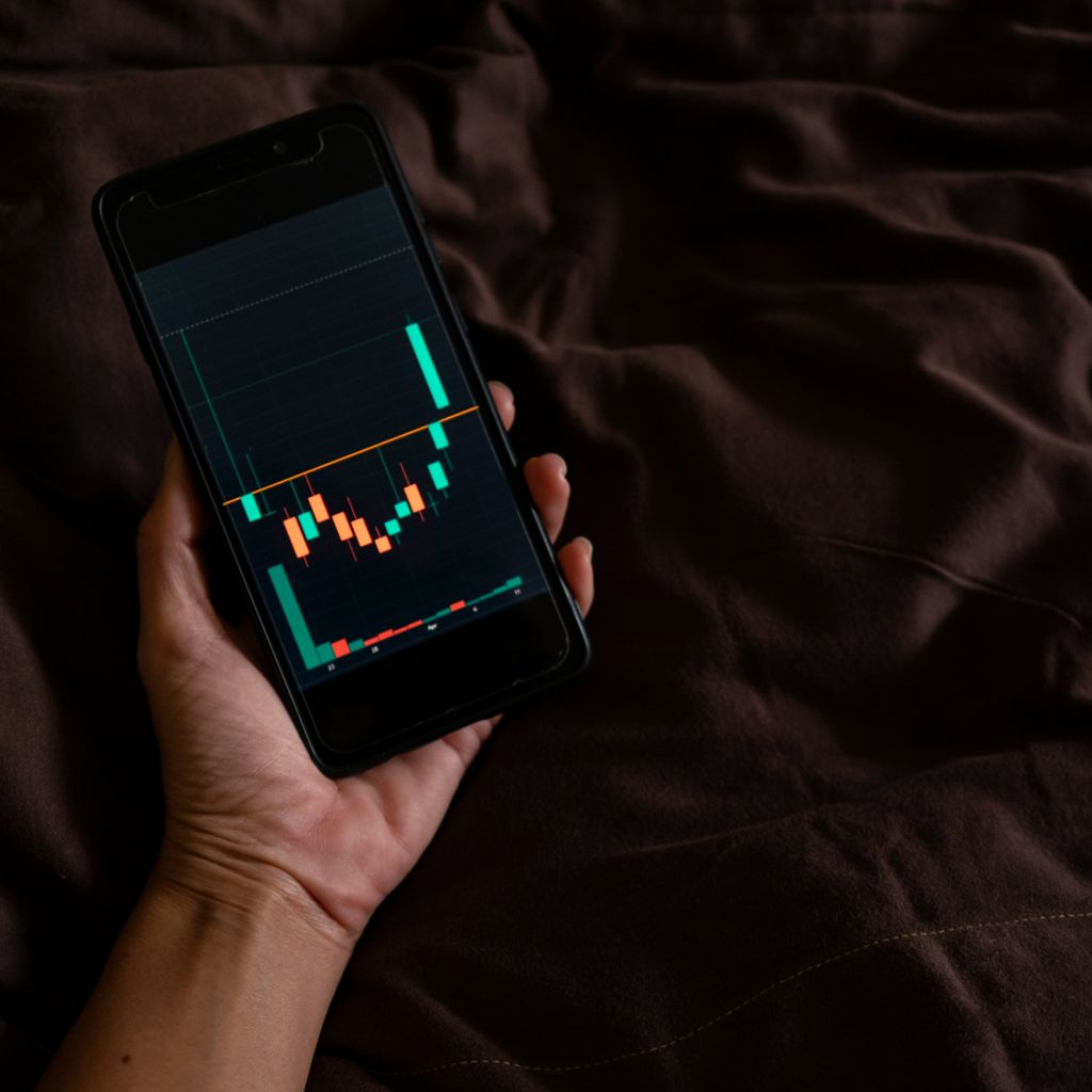 a person holding a cell phone with a chart on the screen