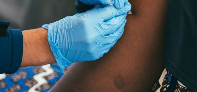 a person in blue gloves is getting a vaccium