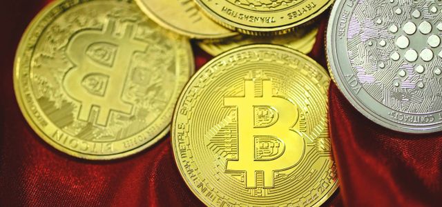 a pile of bitcoins sitting on top of a red cloth