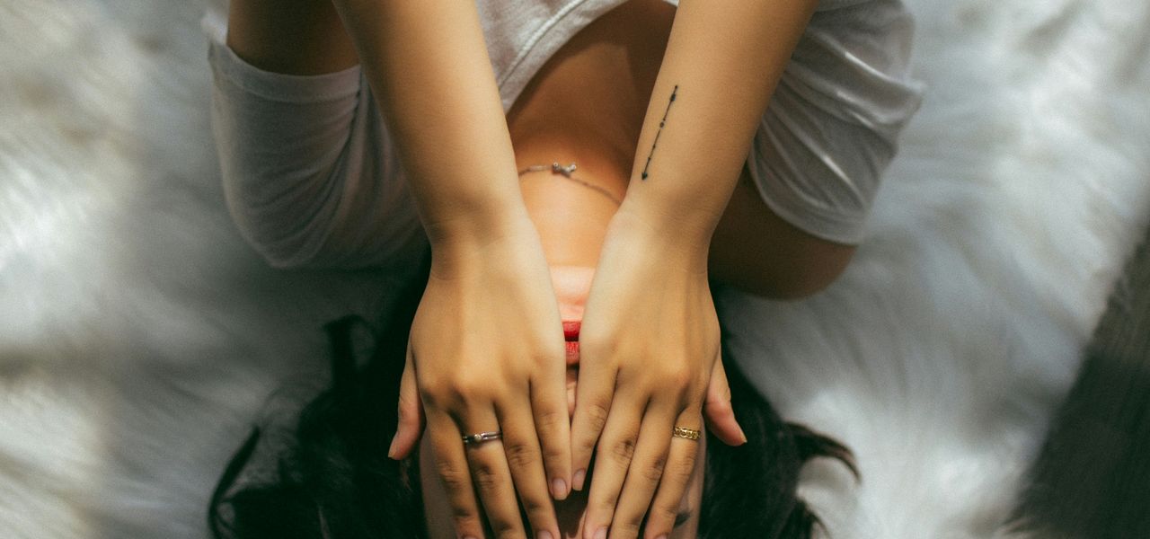 a woman holds her hands over her face