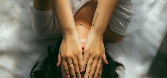 a woman holds her hands over her face