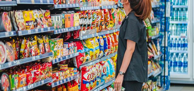 a woman standing in front of a display of food