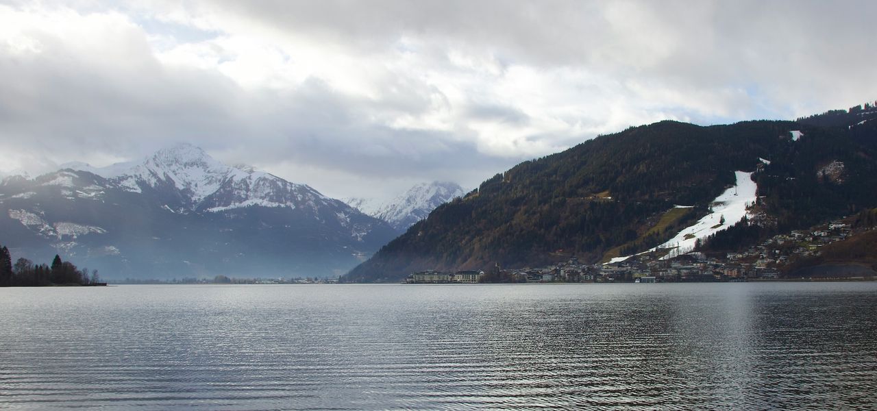 a wooden bench sitting on the shore of a lake