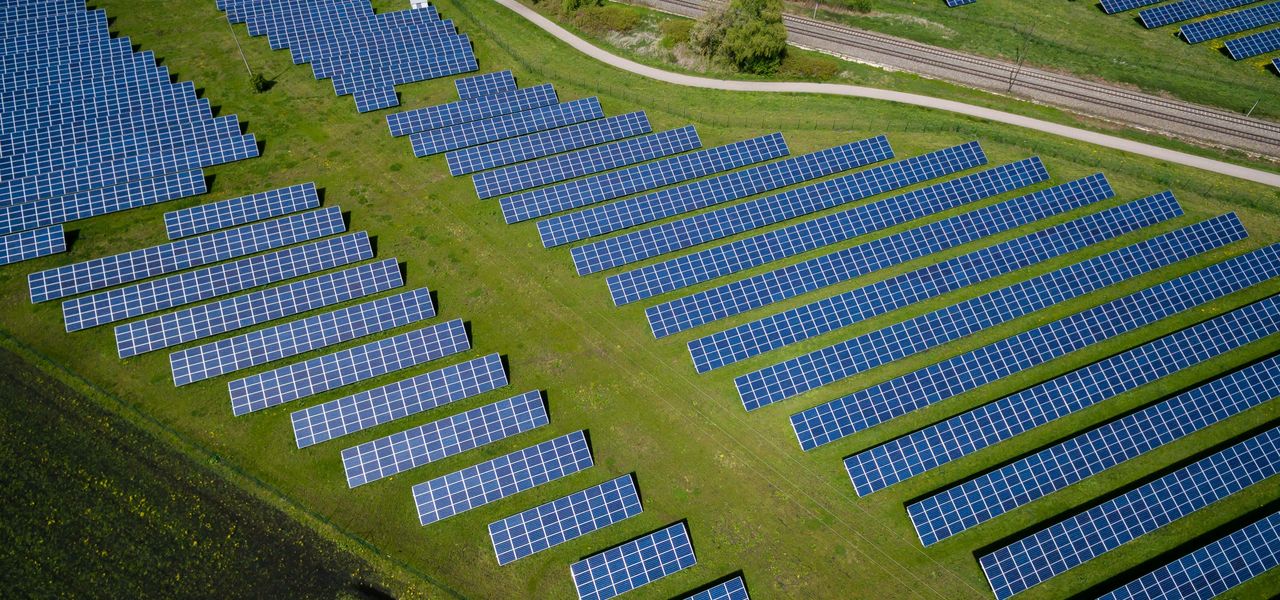 aerial photography of grass field with blue solar panels
