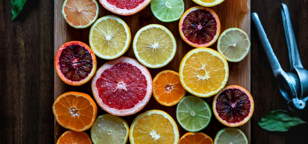assorted sliced citrus fruits on brown wooden chopping board
