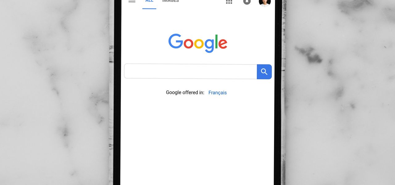 black Android smartphone showing google site on white surface