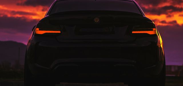 black car on road during sunset