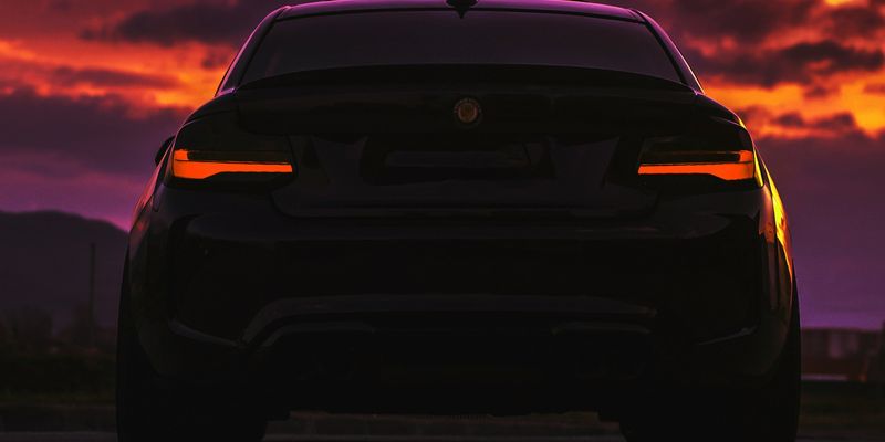 black car on road during sunset