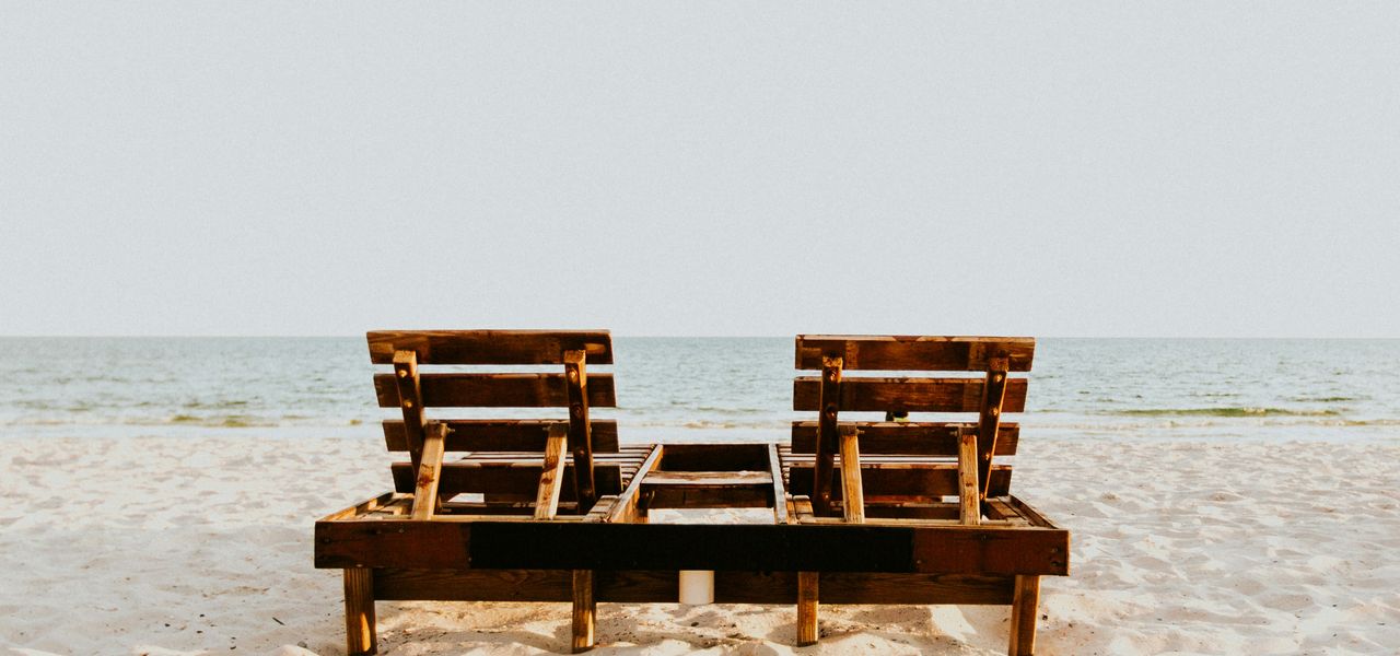 brown wooden chair on white sand beach during daytime
