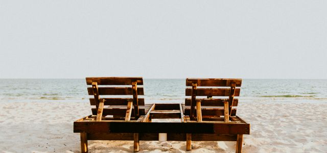 brown wooden chair on white sand beach during daytime