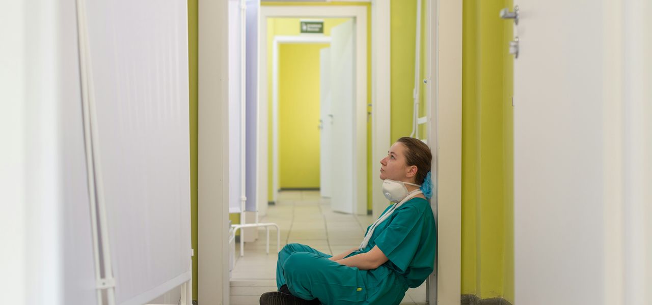 child in blue hoodie sitting on floor