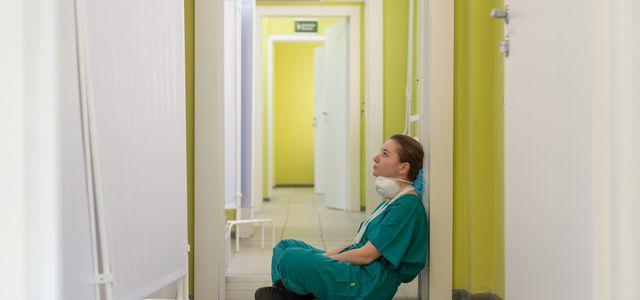 child in blue hoodie sitting on floor