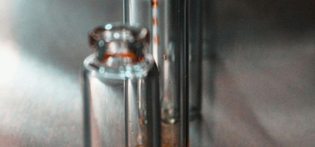 clear glass bottle on white textile