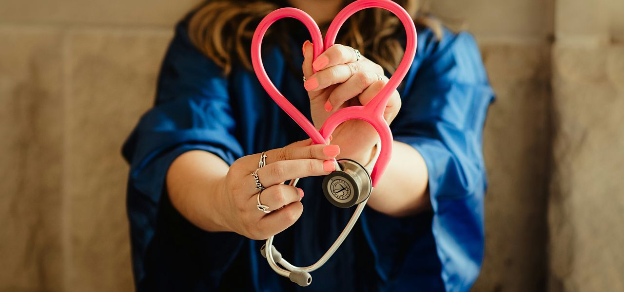 girl in blue jacket holding red and silver ring