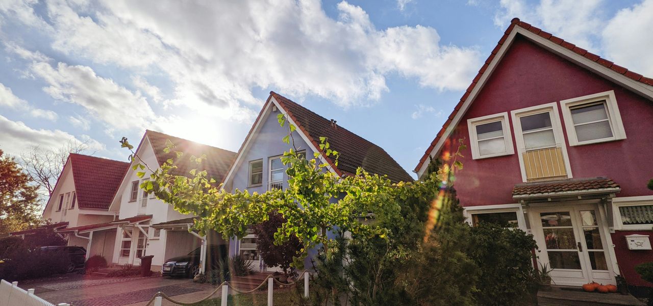 green trees near red and white house under blue sky during daytime