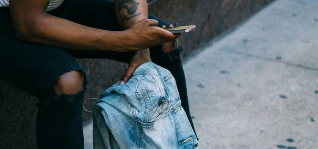man sitting while using phone