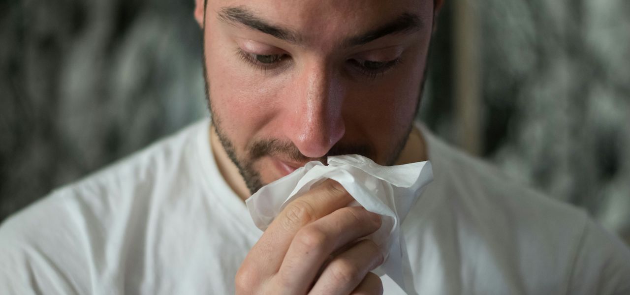 man wiping mouse with tissue paper
